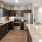 a kitchen with dark wood cabinets and granite countertop island