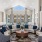 a large lounge room with a large glass wall and a large white balcony