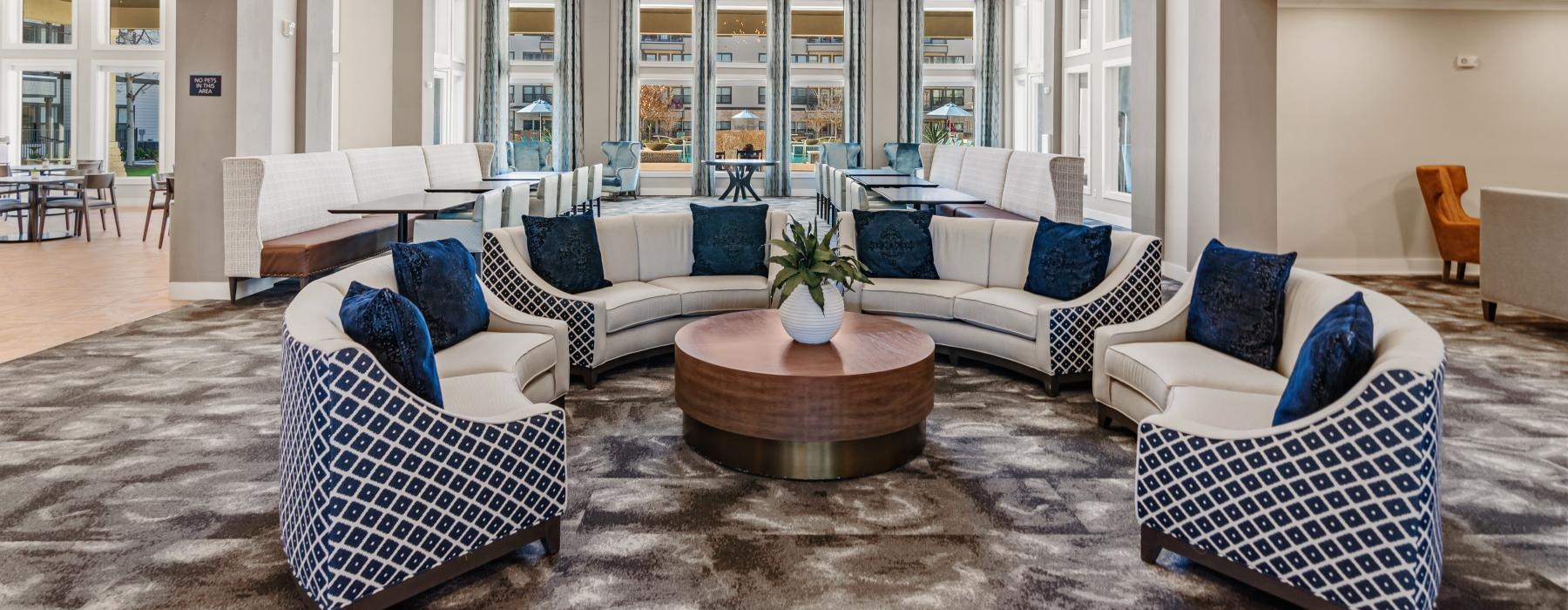 a large lounge room with a large glass wall and a large white balcony