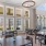 a room with dining tables and chairs and many windows