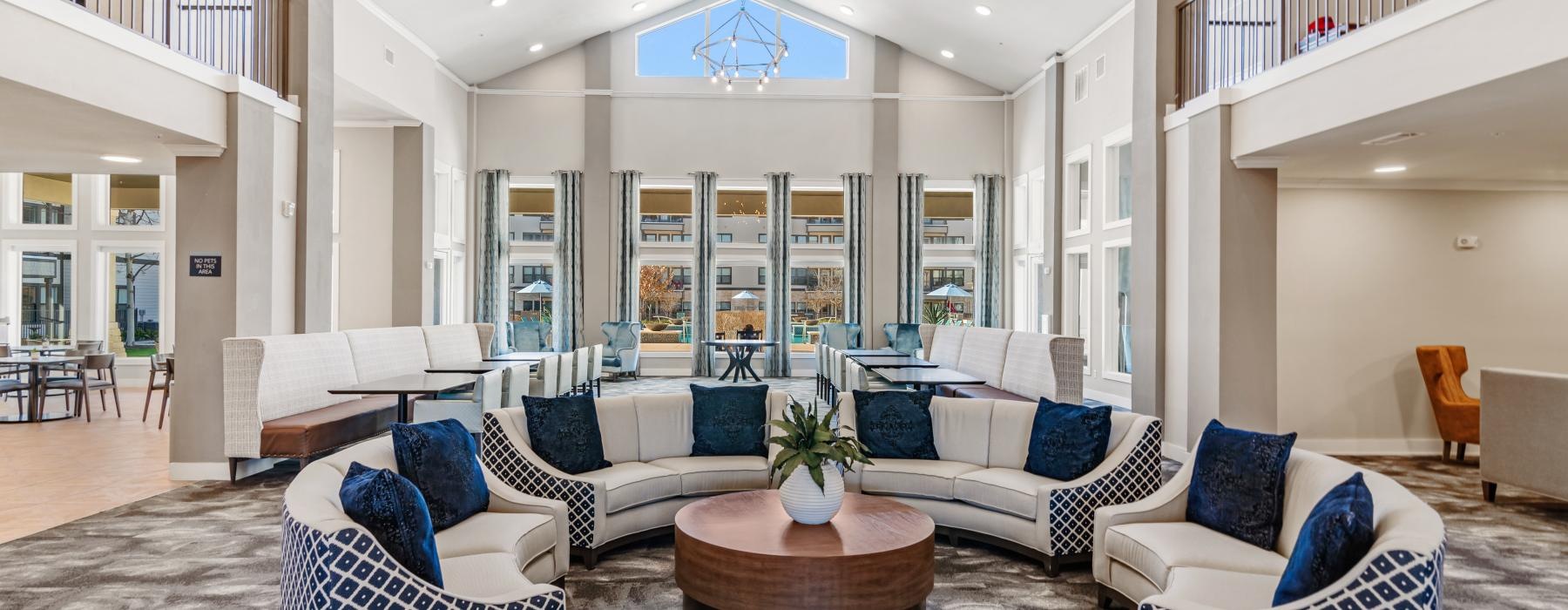 a large lounge room with a large glass wall and a large white balcony